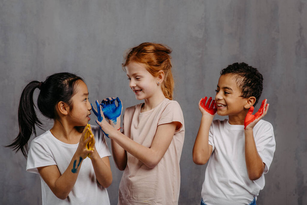 Portret van gelukkige kinderen met geschilderde handen, studio shoot. - Foto, afbeelding