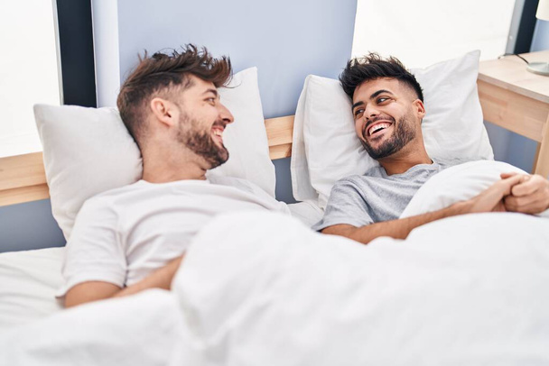 Young couple smiling confident lying on bed at bedrooom - Фото, зображення
