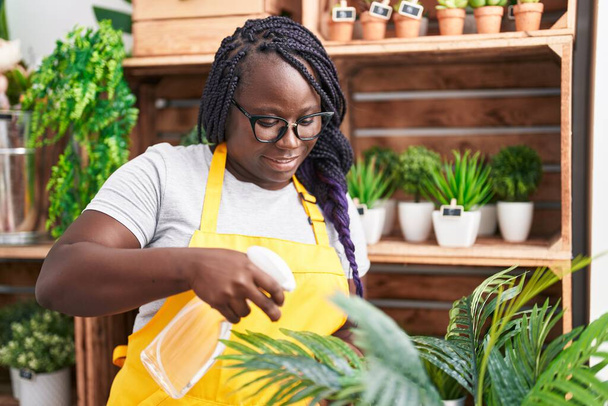 African american woman florist using diffuser working at florist - Photo, Image