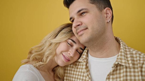 Man and woman couple smiling confident standing together over isolated yellow background - Photo, image