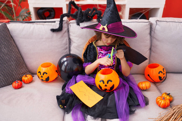 Adorabile ragazza ispanica che indossa la carta da taglio costume di Halloween a casa - Foto, immagini