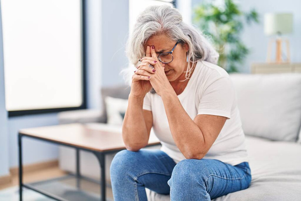 Mulher de meia idade estressado sentado no sofá em casa - Foto, Imagem