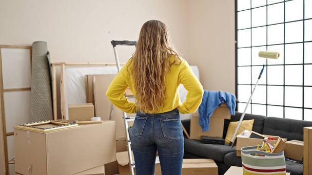 Young blonde woman standing backwards at new home - Foto, Imagem