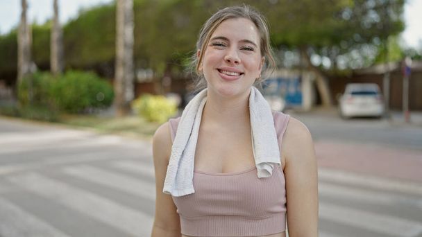 Giovane donna bionda sorridente fiducioso indossa abbigliamento sportivo per strada - Foto, immagini
