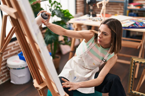 Młoda piękna Latynoska artystka za pomocą graffiti spray rysunek w studio sztuki - Zdjęcie, obraz