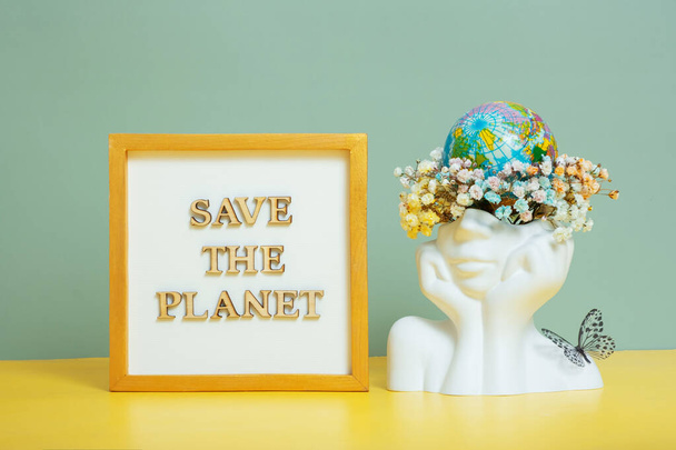 Save the planet text with world globe in head with flowers. Environment for the future, concept of saving the planet. - Photo, Image