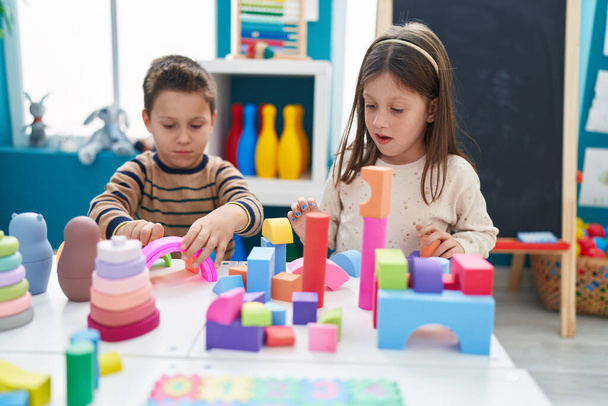Adorável menino e menina brincando com blocos de construção sentados na mesa no jardim de infância - Foto, Imagem