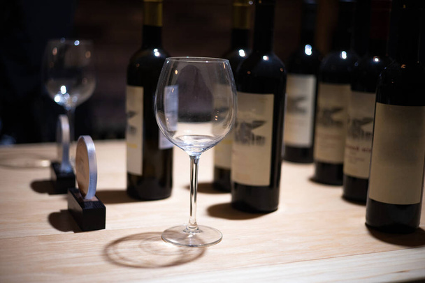 Viinikellari, jossa on pulloja puisilla hyllyillä
 - Valokuva, kuva