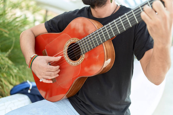 Mladý hispánec muž hudebník hraje klasickou kytaru v parku - Fotografie, Obrázek