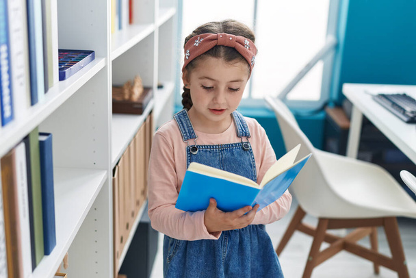 Adorable hispanique fille élève lecture livre à salle de classe - Photo, image
