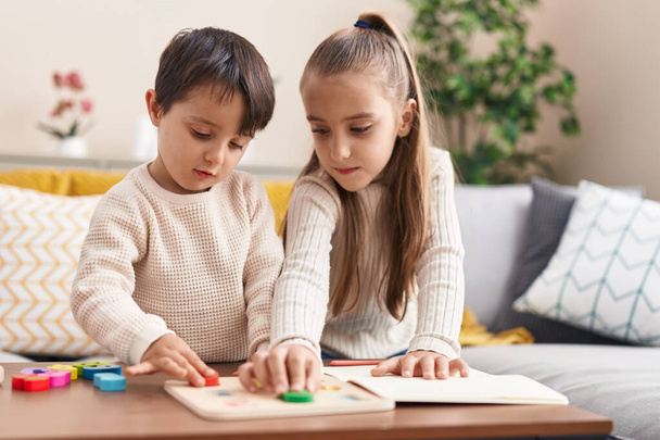 Imádnivaló fiú és lány játszik matematika puzzle játék áll otthon - Fotó, kép