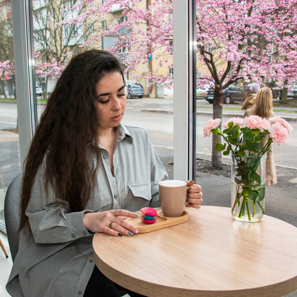 schöne Frau Langhaar sitzt und trinkt Latte in einfachen Café-Café - Foto, Bild