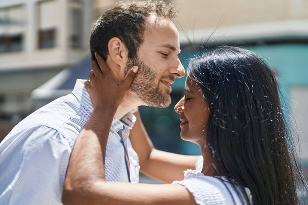 Man and woman interracial couple hugging each other at street - 写真・画像