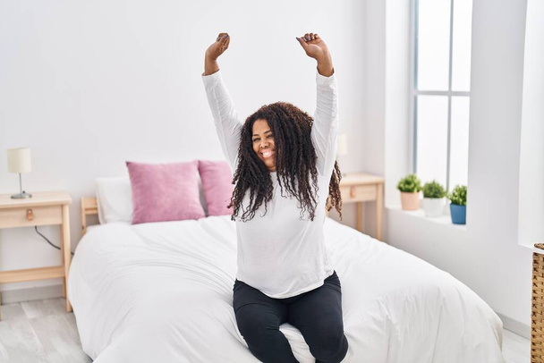 Afričanky americká žena probuzení protáhnout paže v ložnici - Fotografie, Obrázek
