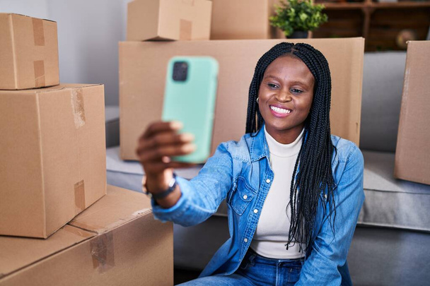 Afro-Amerikan kadın kendine güvenen yeni evinde akıllı telefondan selfie çekiyor. - Fotoğraf, Görsel
