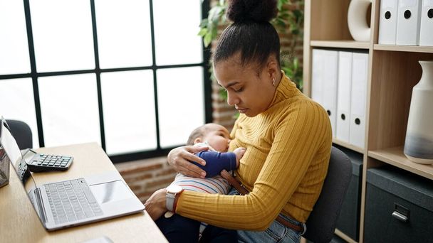 Mother and son business worker working while breastfeeding baby at office - Фото, изображение