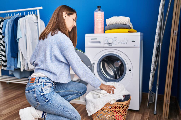 Młoda kobieta pranie ubrań w pralni - Zdjęcie, obraz