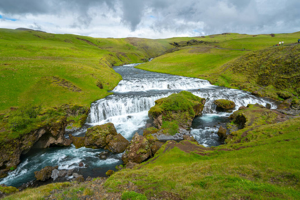 O rio selvagem flui através da paisagem verde na Islândia. Skoga rio de Laugavegur trilha logo acima da famosa cachoeira Skogafoss - Foto, Imagem