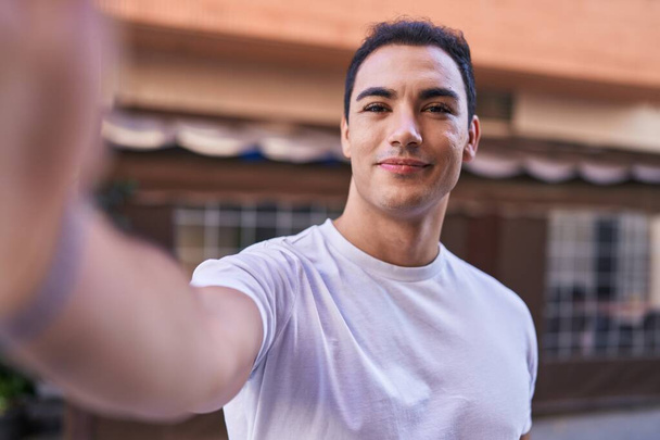 Young hispanic man smiling confident making selfie by camera at coffee shop terrace - Фото, зображення