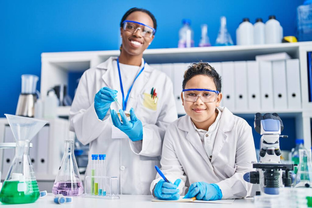 African american mother and son scientists smiling confident working laboratory - Fotoğraf, Görsel