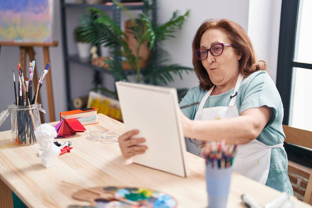 Старша жінка художник малює на блокноті в художній студії
 - Фото, зображення