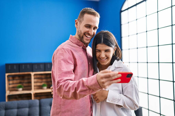 Férfi és nő pár mosolygós magabiztos segítségével smartphone otthon - Fotó, kép
