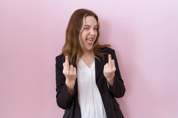 Young caucasian business woman wearing black jacket showing middle finger doing fuck you bad expression, provocation and rude attitude. screaming excited  - Valokuva, kuva