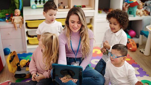 Mujer y grupo de niños que tienen clase usando touchpad en el jardín de infantes - Foto, Imagen