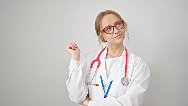 Young blonde woman doctor looking to the side with serious expression over isolated white background - Photo, Image