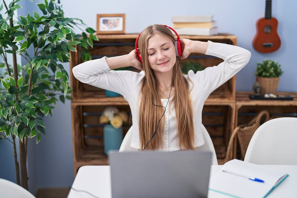 Young caucasian woman listening to music studying at home - Photo, image