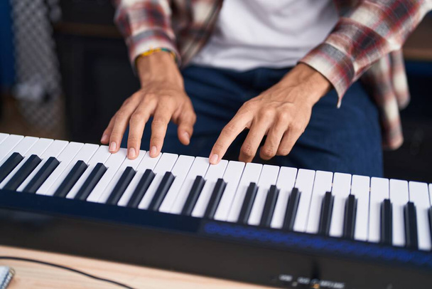 Young hispanic man musician playing piano at music studio - Foto, afbeelding