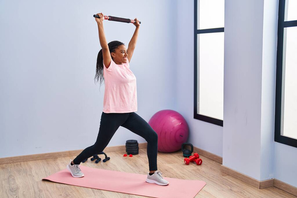 Afričanky americká žena s úsměvem sebevědomý trénink nohy cvičení ve sportovním centru - Fotografie, Obrázek