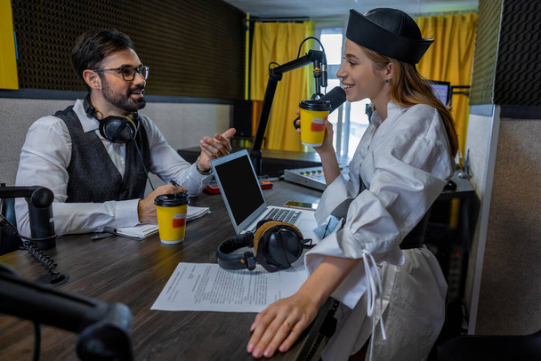 At the radio studio. Young girl talking with dark-haired man - Foto, Imagen