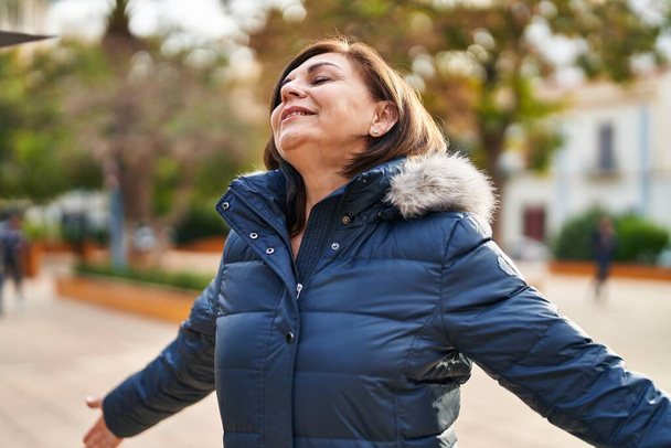 Жінка середнього віку дихає закритими очима в парку
 - Фото, зображення