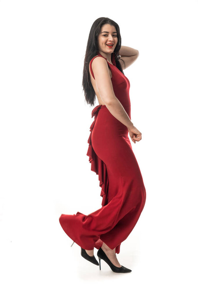 fiatal vonzó hosszú haj barna modell nő piros ruha gesztikuláló fehér háttér - Fotó, kép
