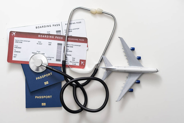 assicurazione sanitaria nel concetto di viaggio. cure mediche all'estero. stetoscopio, aereo giocattolo e passaporti. - Foto, immagini