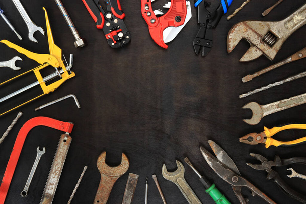 Flat lay composition with old and new instruments on a dark wooden background. Top view with various repair tools. Tools and empty space for text - Φωτογραφία, εικόνα