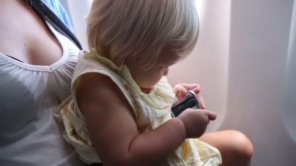 Little girl fasten belt in airplane - Záběry, video