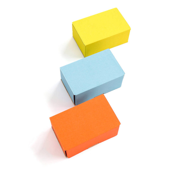 Colored craft boxes on a white background. Orange, blue, yellow. Place for text and logo. The concept of packaging, holiday, gifts. High quality photo - 写真・画像