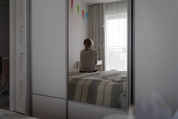 Mature woman sitting alone in the room, sad depressed person. Back view. mental health problemageing population. High quality photo - Foto, Imagem
