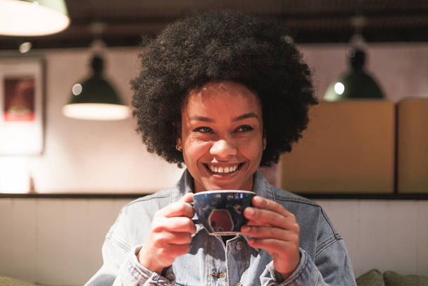 afro woman holding cup of coffee, big smile, closeup portrait. High quality photo - Fotó, kép