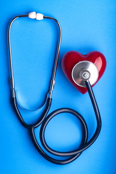 Medical Stethoscope and red heart on blue background, top view. Space for text. - Photo, image