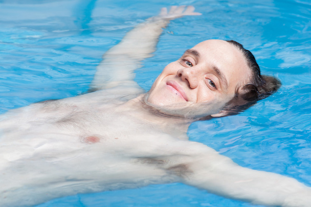 Uomo galleggiante in piscina
 - Foto, immagini