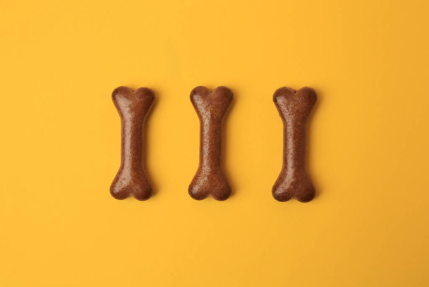 Bone shaped dog cookies on orange background, flat lay - Foto, Imagem