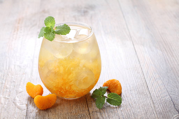 Ice fresh orange with mint leaf garnish - Foto, afbeelding