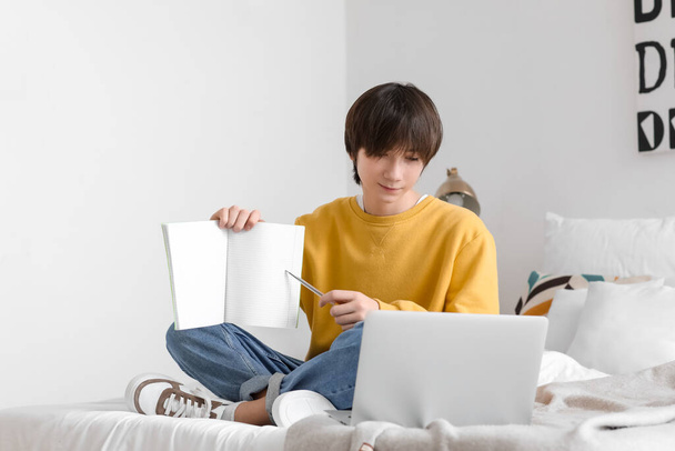 Male student with notebook studying online at home - Foto, Imagem