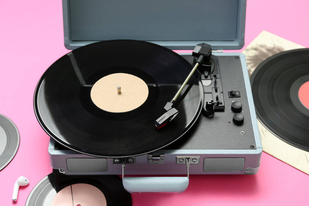 Record player with vinyl disks on pink background, closeup - Photo, Image