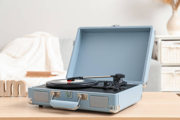 Lecteur de disque avec disque vinyle sur la table dans la chambre - Photo, image