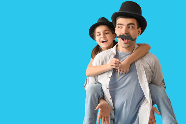 Retrato de pai e sua filhinha com bigode de papel no fundo azul claro - Foto, Imagem