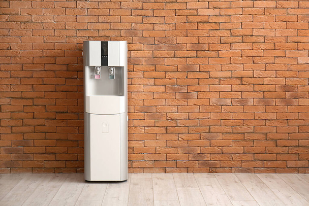 Modern water cooler near brick wall - Fotografie, Obrázek